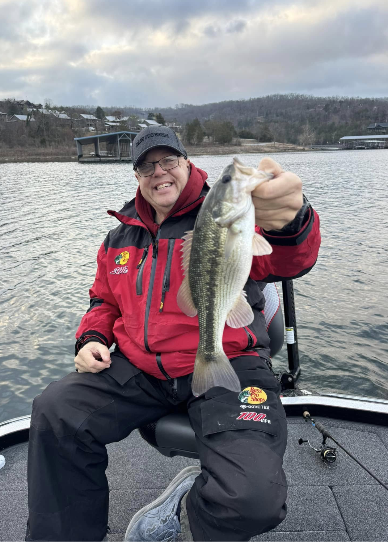 Kid angler with a big smallmouth bass on the water